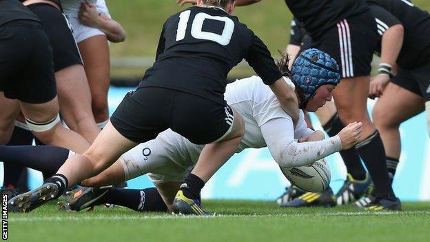 Rochelle Clark (in white) scores a try for England