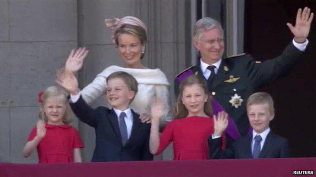 King Philippe, his wife Mathilde and their four children wave to crowds from the balcony of the royal palace in Brussels