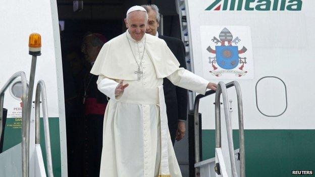 Pope Francis waves upon arrival at Antonio Carlos Jobim International Airport in Rio de Janeiro