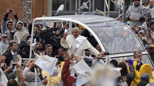 The pontiff waves to pilgrims from his Popemobile as he arrives at the Aparecida Basilica