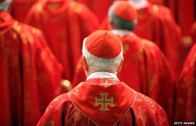 Cardinal dressed in red, photographed from behind