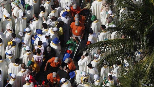 Rescue workers carry a pilgrim on a stretcher (28 July 2013)