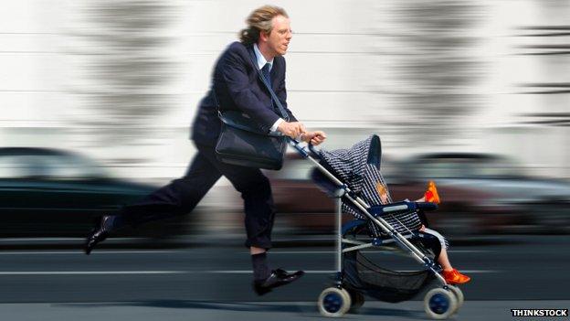 A man in a suit is running while pushing a pram with a baby inside