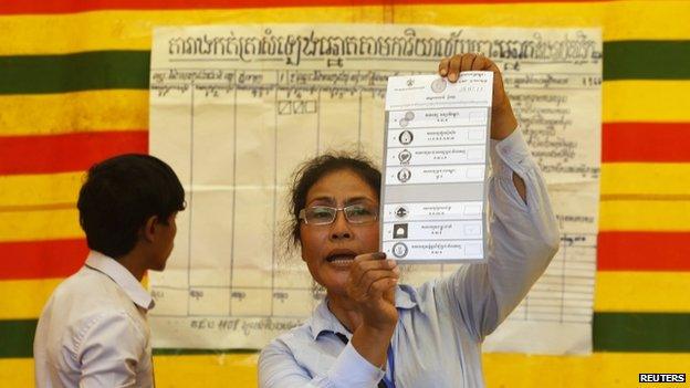 An election official displays a ballot paper