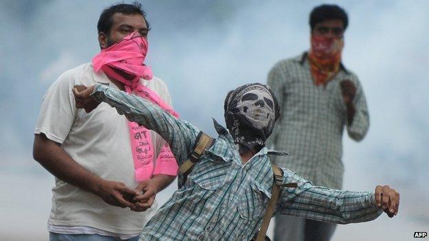 A Telangana Joint Action Committee (T-JAC) activist throws stones towards police during a pro-Telangana protest in Hyderabad on June 14, 2013.