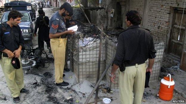 Policemen collect evidence outside the Dera Ismail Khan prison on Tuesday