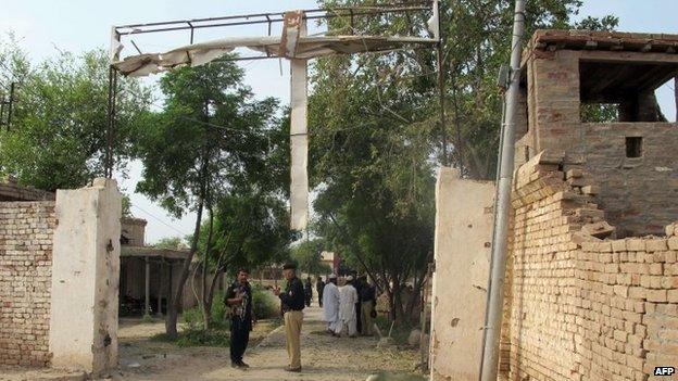 Pakistani policemen stand guard outside the Central Prison on Tuesday after an overnight armed Taliban militant attack in Dera Ismail Khan, Khyber Pakhtunkhwa province