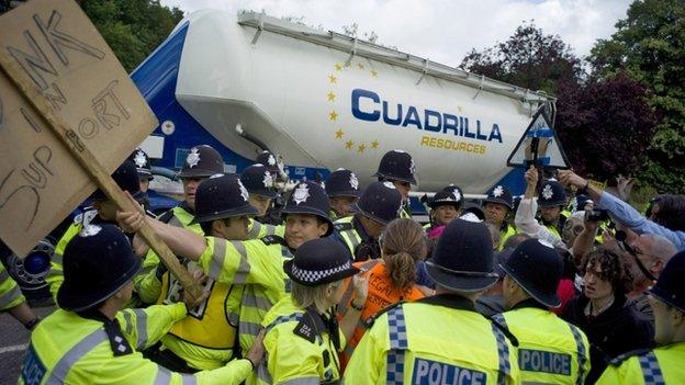 Demonstrators try to stop police officers and a lorry