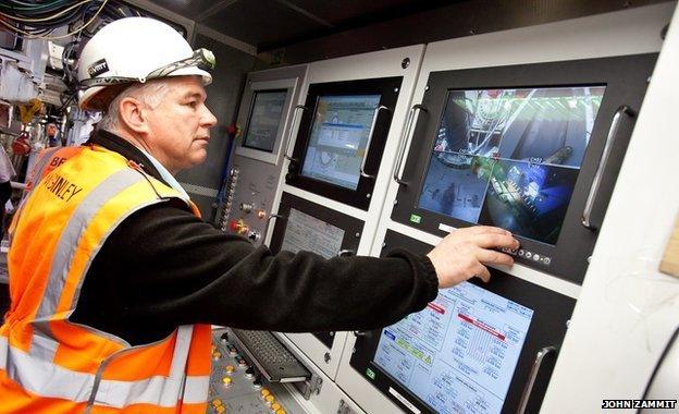 A technician operating a tunnel boring machine