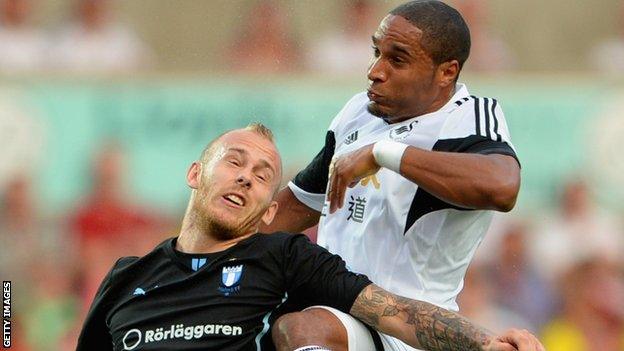 Malmo's Magnus Eriksson challenges Ashley Williams