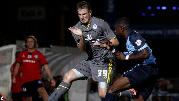 Leicester's Chris Wood (left) braces himself in the air against the clearance from Wycombe's Kortney Hause