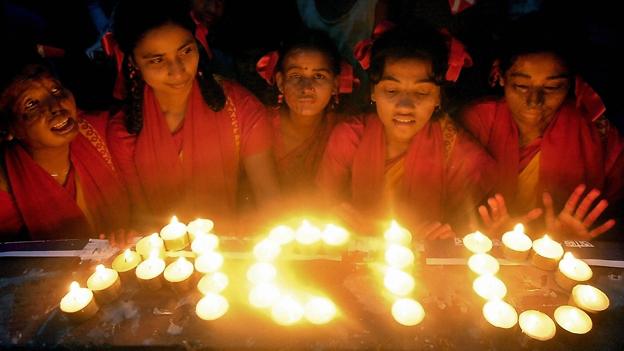 Young Bangladeshi acid attack victims use candles to write the word "Acid"