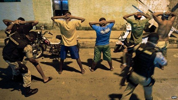 Military policemen frisk residents during an operation at the Brejal shantytown in Maceio