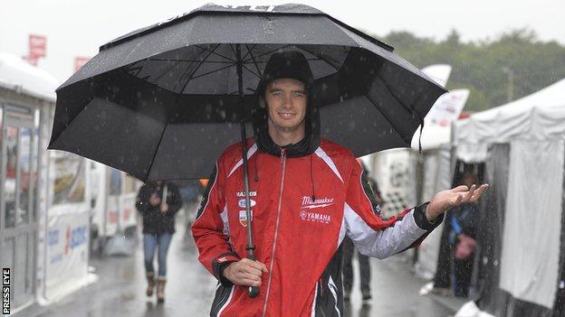 Road racer Conor Cummins takes shelter from the rain after the Dundrod 150 had to be abandoned