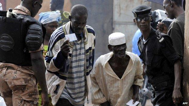 Police check the IDs of people arriving at a polling station during the presidential elections in Mali on 11 August 2013 in Bamako