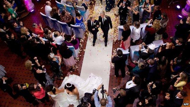 Richard Rawstorn (L) with Richard Andrew walk down the isle after getting married during one of the country's first same-sex marriages at the Rotorua Museum in Rotorua on Monday