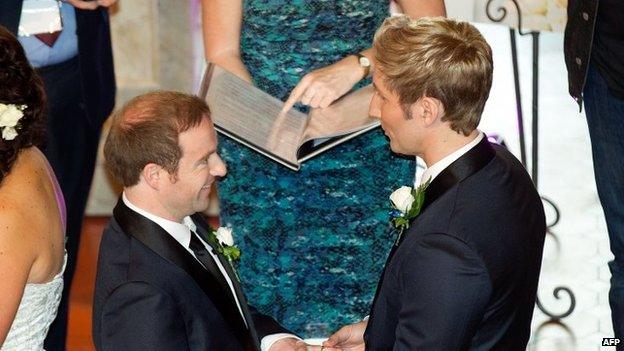 Richard Andrew (R) places a ring on the finger of Richard Rawstorn as they are married during one of the country's first same-sex marriages at the Rotorua Museum in Rotorua on Monday