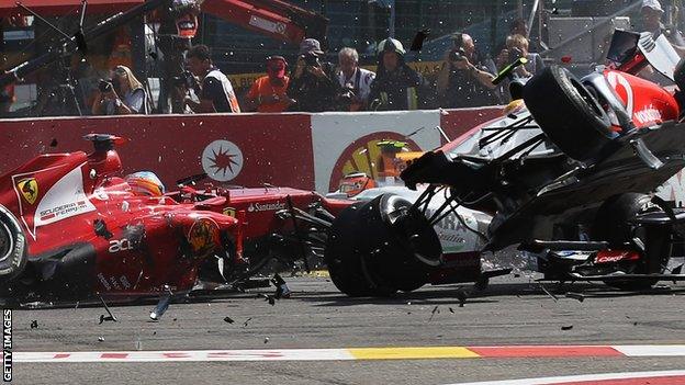 Fernando Alonso (L) of Spain and Ferrari and Lewis Hamilton (R) of Great Britain and McLaren collide and crash out at the first corner at the start of the 2012 Belgian Grand Prix