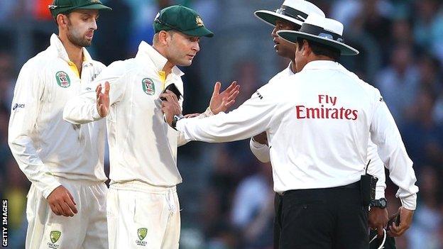 Umpires Aleem Dar and Kumar Dharmasena discuss the light in rather animated fashion with Australia captain Michael Clarke