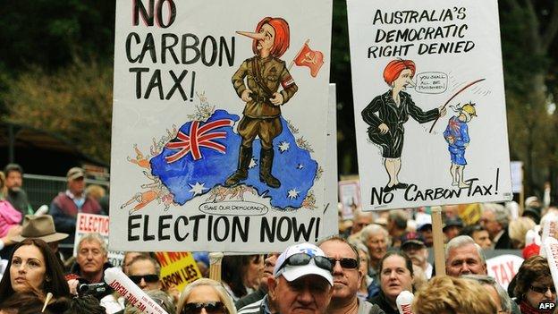 Protesters hold placards as they attend a rally in Sydney on 1 July 2012