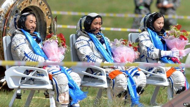 Chinese astronaut (L-R) Zhang Xiaoguang, Nie Haisheng and Wang Yaping sit on their chairs after getting out of the Shenzhou-10 spacecraft that landed on the grasslands of north China's Inner Mongolia region on 26 June, 2013, after a 15-day mission in space.