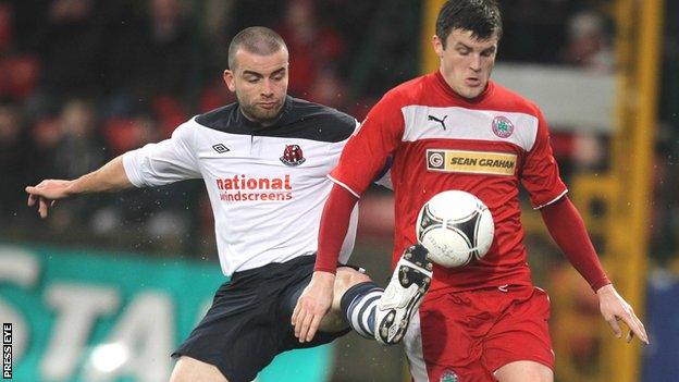 Colin Coates gets his toe to the ball ahead of Cliftonville's Diarmuid O'Carroll