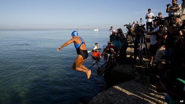 Diana Nyad jumping into the sea while the media watch on