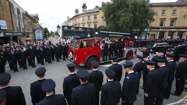 Firefighters lining the streets as a fire engine carries Stephen Hunt's coffin