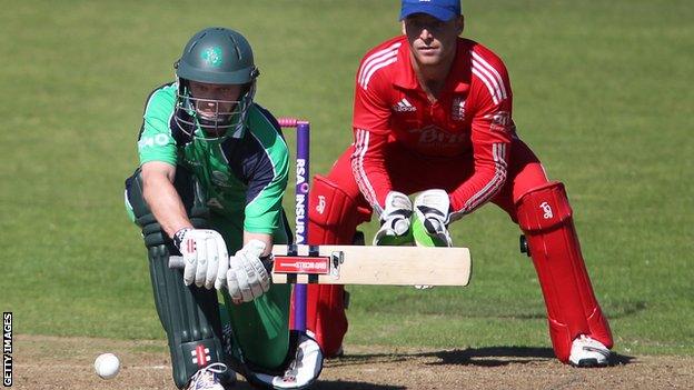 William Porterfield is about to attempt a sweep shot as England wicketkeeper Jos Buttler crouches behind the stumps