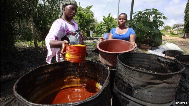 Women prepare to extract red palm oil in Dabou, around 49 km (30 miles) from Abidjan on 12 June 2013