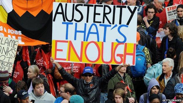 A man holds a sign saying "Austerity that's enough"