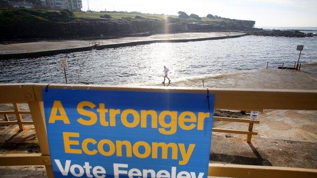 Swimmers exit the water as polls open in Clovelly Beach on 7 September 2013