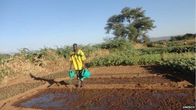 A member of the refugee community at the Kakuma refugee camp watering his vegetables, Turkana, Kenya