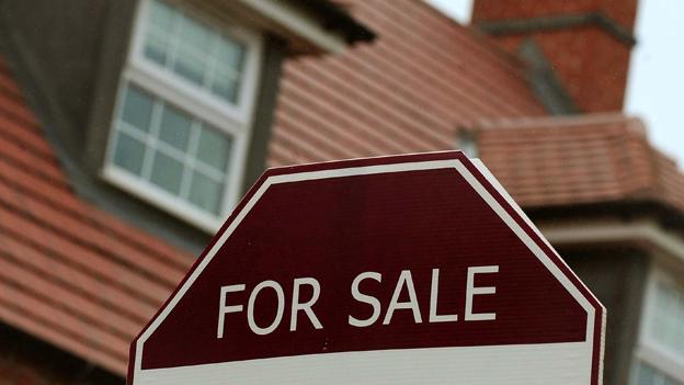 For sale sign in front of a house