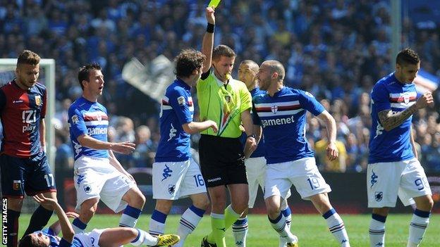 A player is booked during a Sampdoria v Genoa derby match