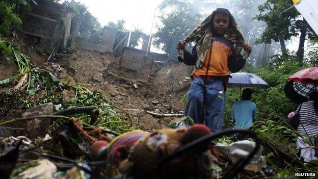 A boy stands in a neighbourhood where several people were killed after a house collapsed in a landslide in Acapulco on 15 September, 2013.