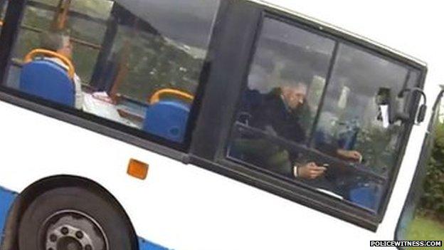 driver apparently using a mobile telephone while driving a bus
