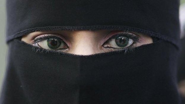 Girl wears a niqab veil which reveals only her eyes