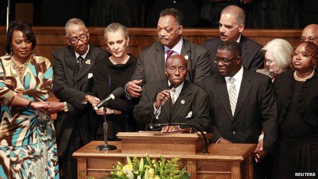 Rev Calvin Woods led the singing of We WIll Overcome during a community memorial service at the church to mark the anniversary