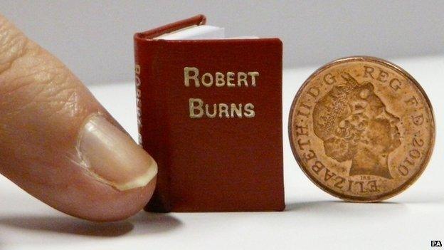 A book next to a penny. The book is only slightly larger than the penny.