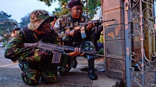 Kenyan soldiers take cover after heavy gunfire near Westgate mall in Nairobi on 23 September 2013