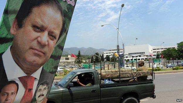 An army vehicle drives past a poster of Pakistan's Premier-elect Nawaz Sharif near parliament in Islamabad on June 5, 2013.