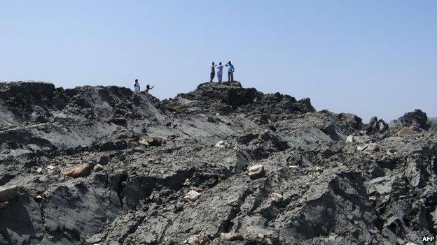 In this photo released by the Pakistani Government, Pakistani men walk on an island that appeared two kilometres off the coastline of Gwadar on 25 September, 2013, after an earthquake.