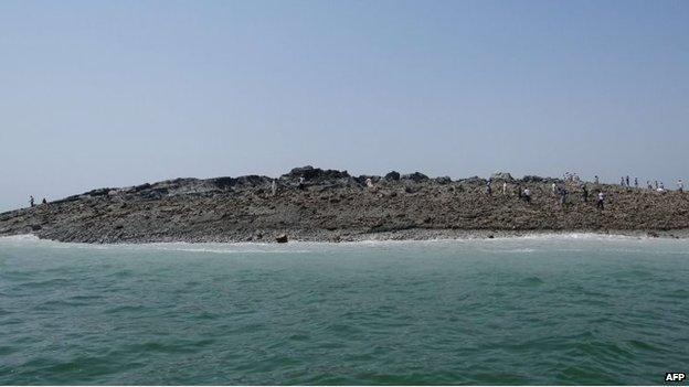 In this photo released by the Pakistani Government, Pakistani men walk on an island that appeared 2 kilometres off the coastline of Gwadar on 25 September, 2013.