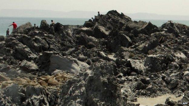 In this photo released by the Pakistani Government, Pakistani men walk on an island that appeared 2 kilometres off the coastline of Gwadar on 25 September, 2013.