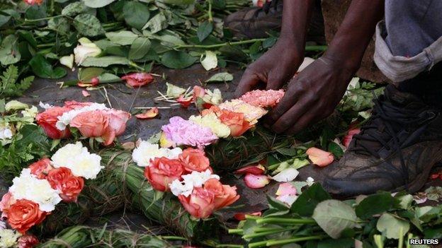 A trader prepares flowers in the shape of a cross for sale outside the City Mortuary in Nairobi