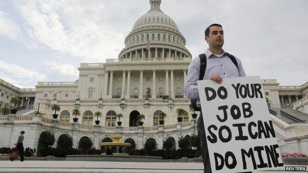 A furloughed federal employee holds a sign on the steps to the US Capitol after the US government shut down last night, on Capitol Hill in Washington on 1 October 2013.