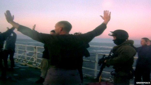 An image released by Greenpeace shows a member of Russia's security forces (2nd R) standing on the deck of the Arctic Sunrise Greenpeace's icebreaker shortly after boarding the ship involved in a high seas protest against Arctic oil drilling.