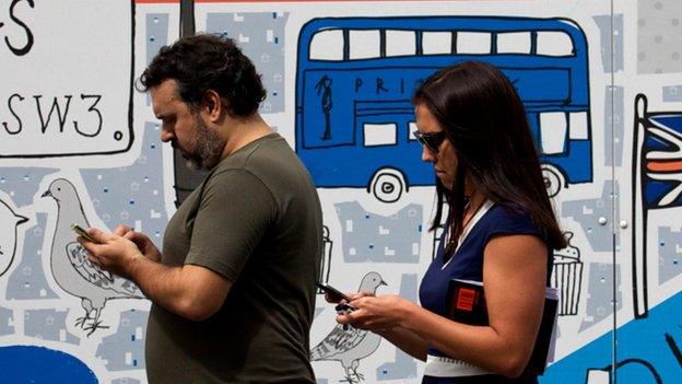 Man and woman holding phones