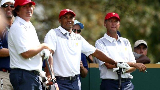 US team members Jason Dufner (L) and Tiger Woods and assistant captain Davis Love III